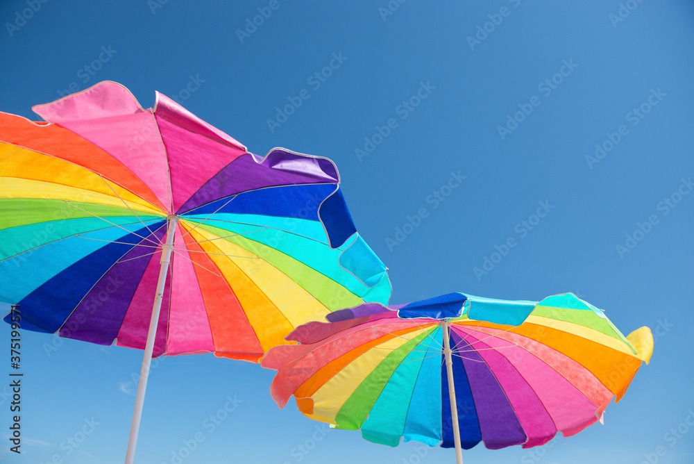 Colorful beach umbrellas against a blue summer sky